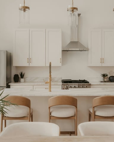 White kitchen with brass pendant lights and island bar seating